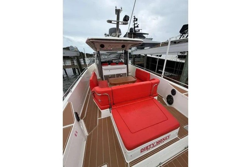 Dirty Money Yacht Photos Pics 2021 Nimbus T-11 boat with red seating, docked at marina.