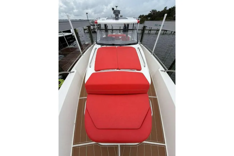 Dirty Money Yacht Photos Pics 2021 Nimbus T-11 boat with red cushions, docked by the water.