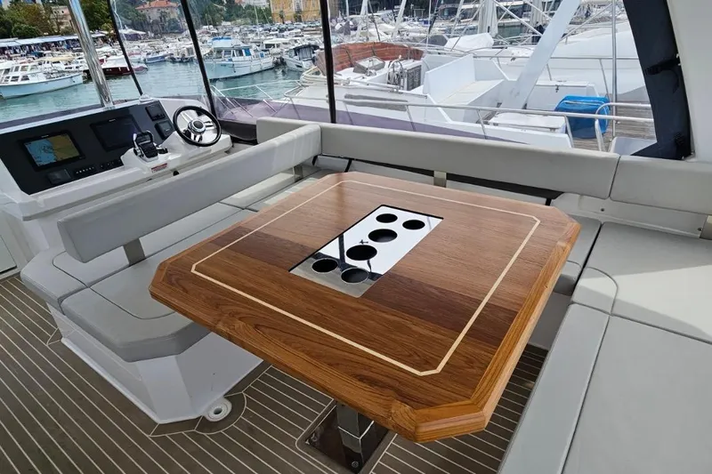  Yacht Photos Pics 2023 Leopard 40 Powercat interior with helm, wooden table, and marina view.