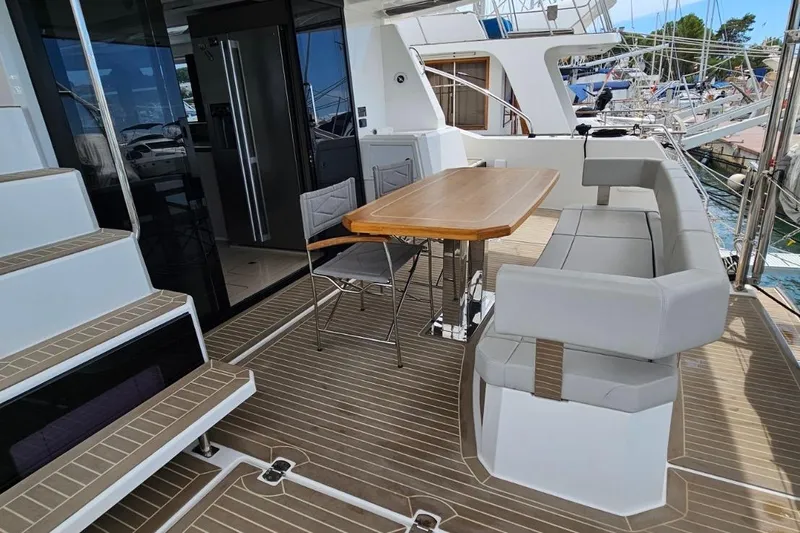  Yacht Photos Pics 2023 Leopard 40 Powercat yacht deck with seating, table, and stairs.