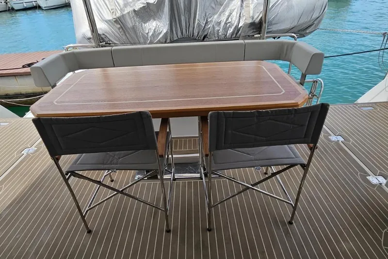  Yacht Photos Pics Outdoor dining area on 2023 Leopard 40 Powercat yacht with wooden table and chairs.