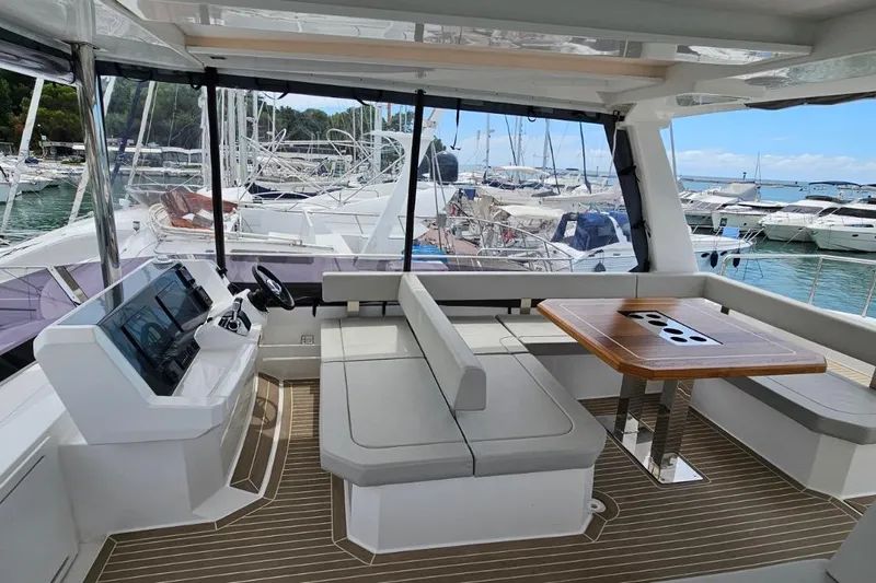  Yacht Photos Pics 2023 Leopard 40 Powercat interior with helm, seating, and table in marina setting.