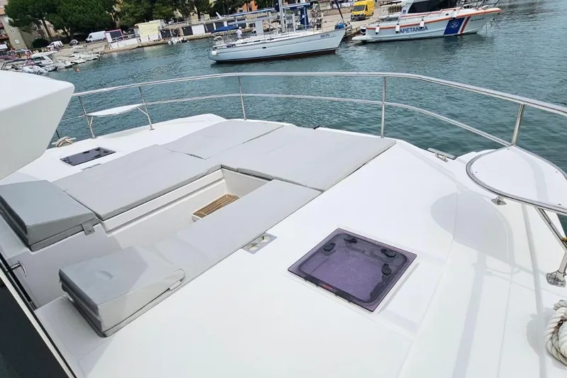  Yacht Photos Pics 2023 Leopard 40 Powercat deck with sunbathing area, docked at marina.