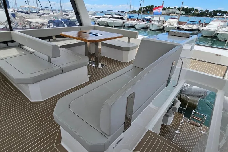  Yacht Photos Pics 2023 Leopard 40 Powercat yacht interior with sleek seating and wooden table, docked at marina.