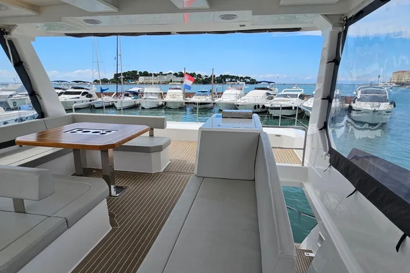  Yacht Photos Pics 2023 Leopard 40 Powercat interior with marina view, featuring seating and dining area.