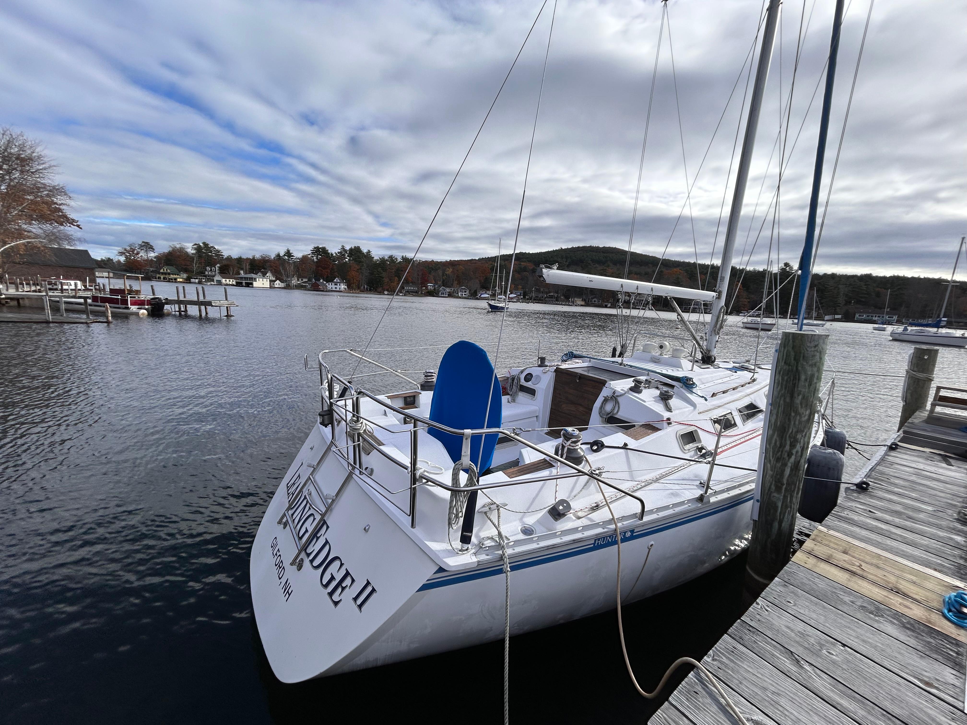 1983 Hunter 34 sailboat docked at a marina under cloudy skies.
