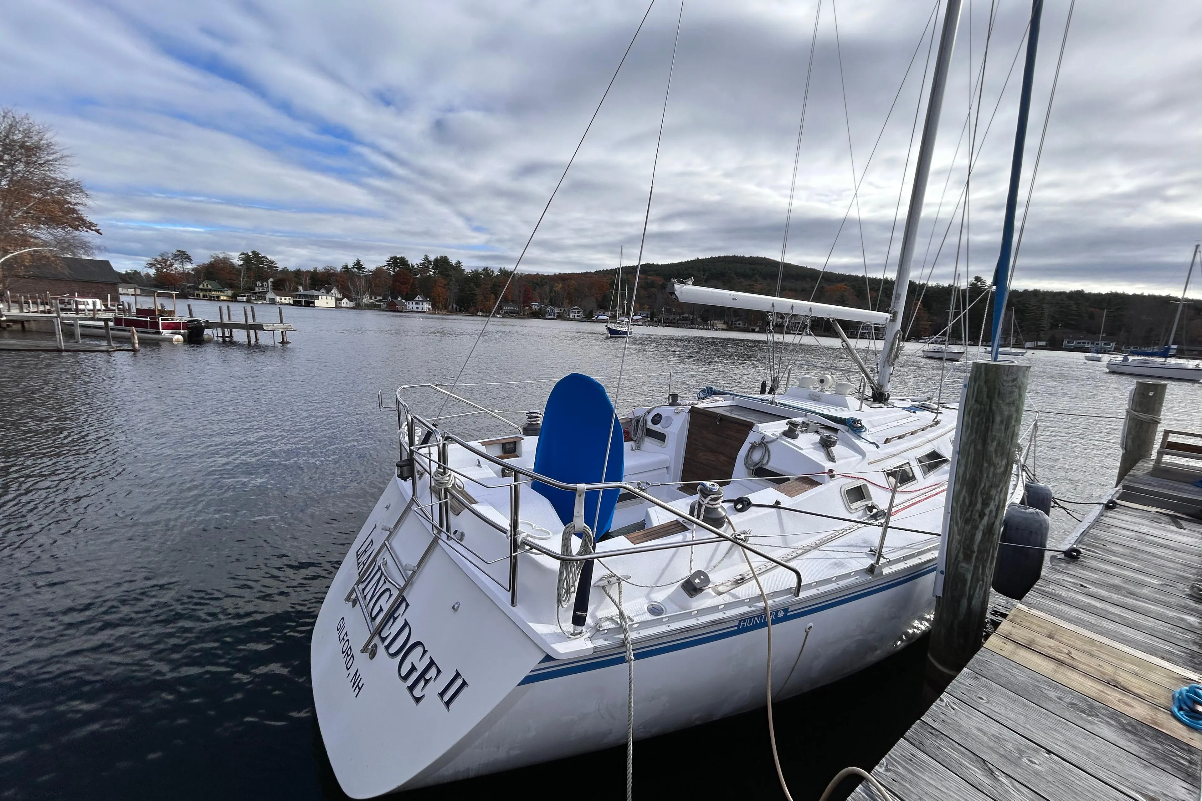 1983 Hunter 34 sailboat docked at a marina under cloudy skies.