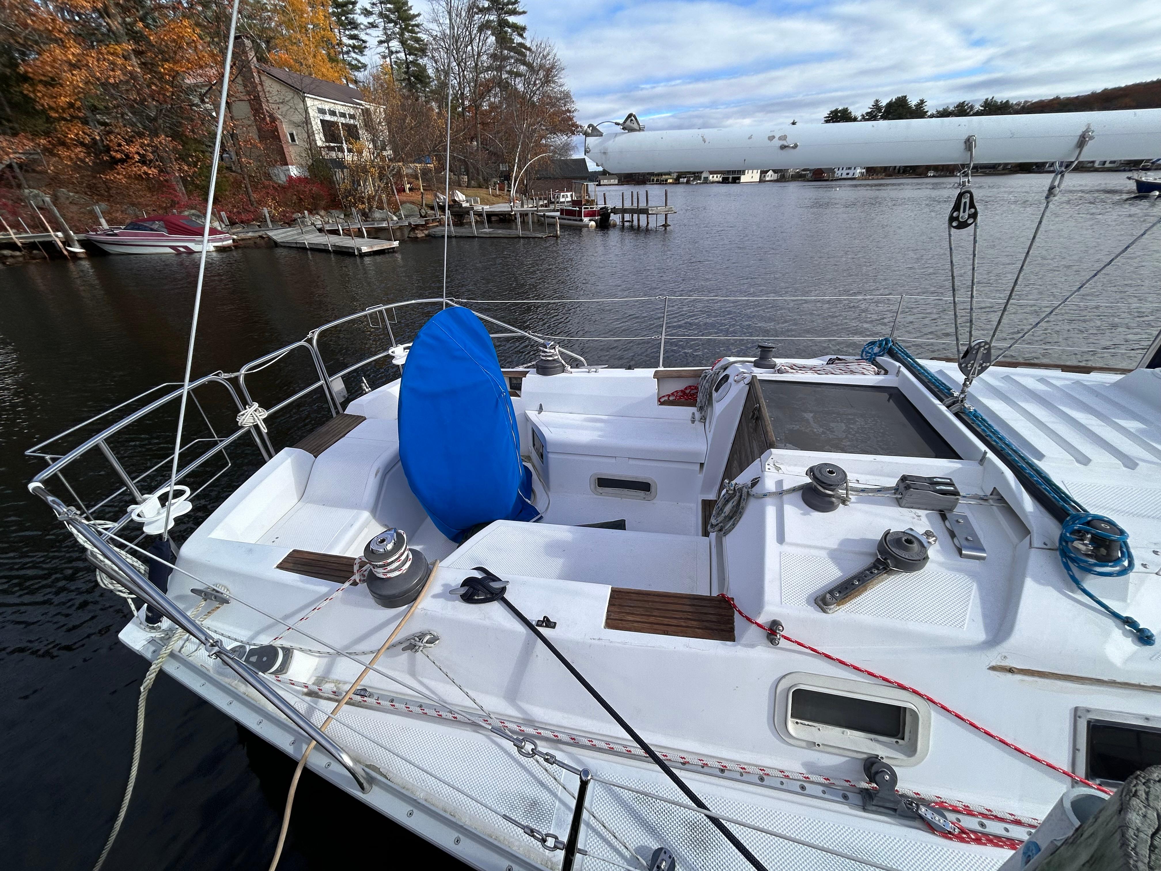 1983 Hunter 34 sailboat docked on a calm lake with autumn foliage.