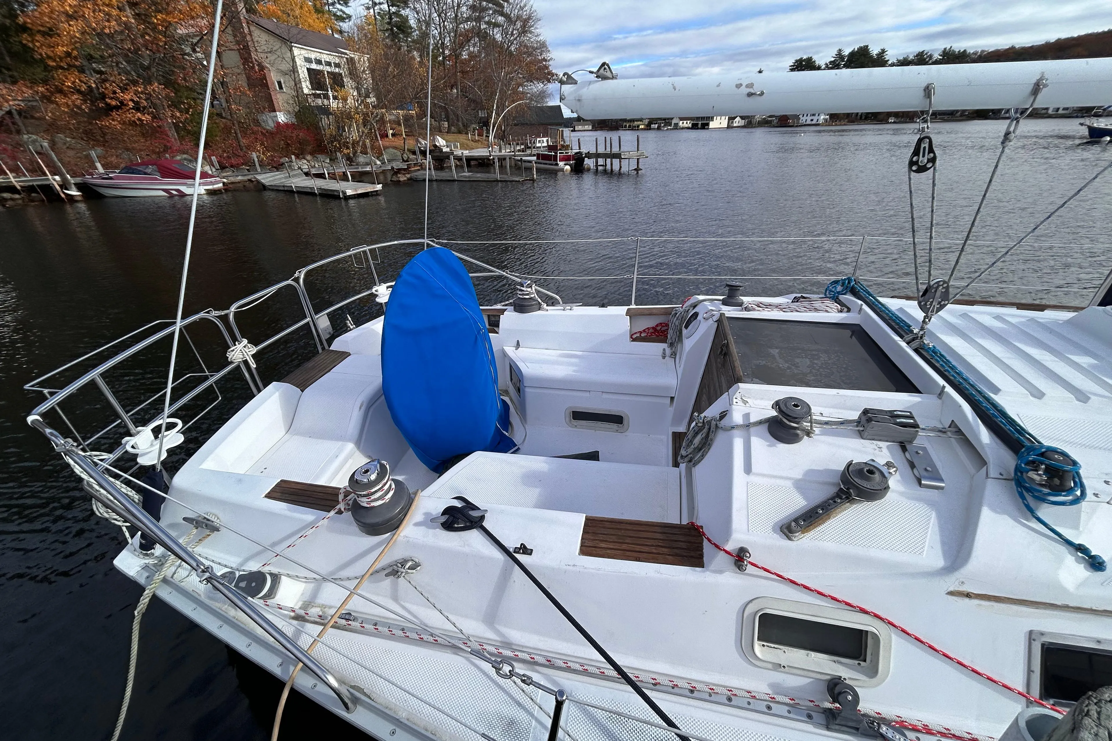 1983 Hunter 34 sailboat docked on a calm lake with autumn foliage.