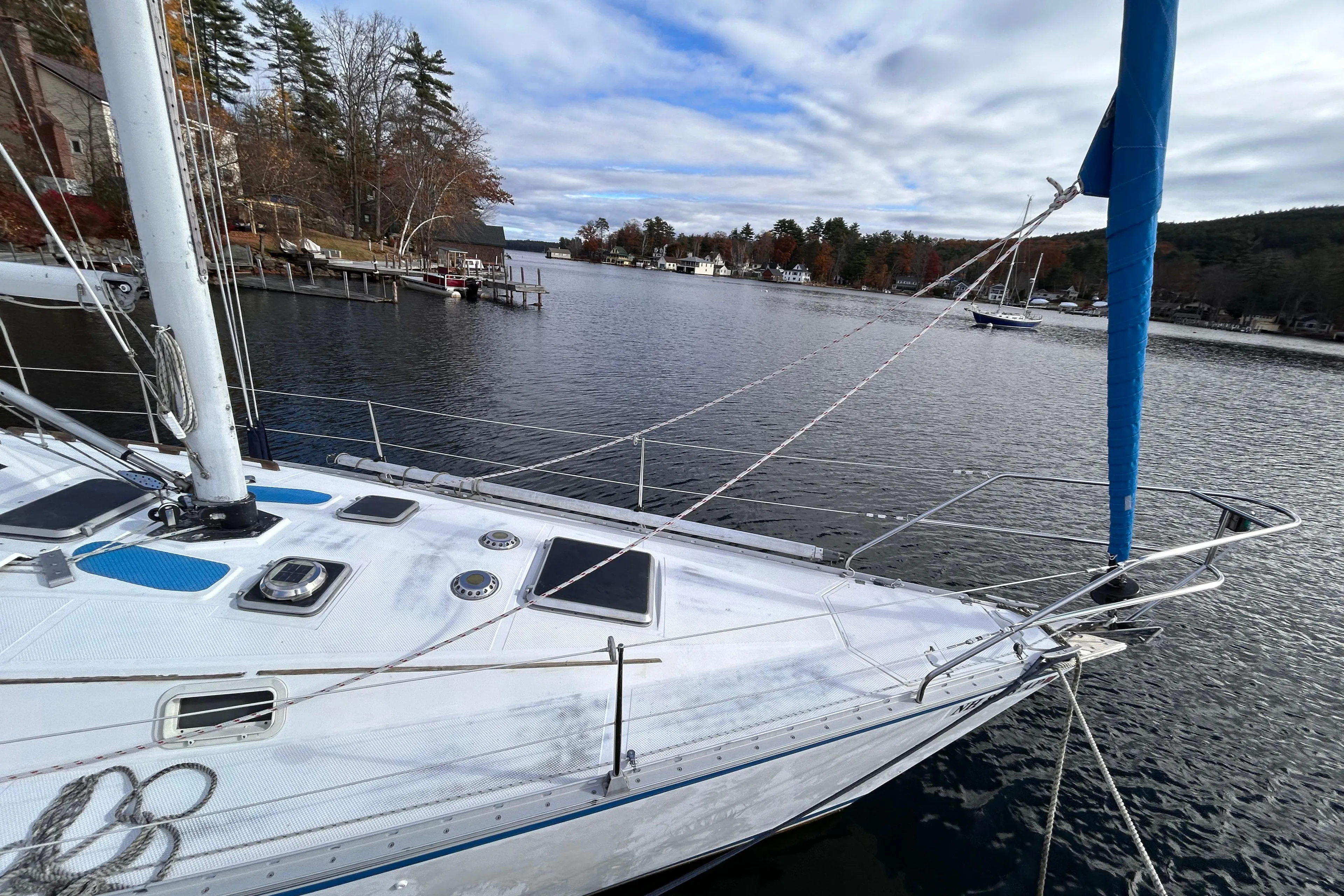 1983 Hunter 34 sailboat docked on a serene lake with a scenic backdrop.