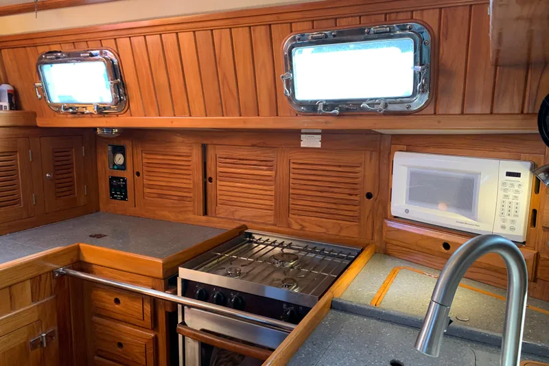 Elation Yacht Photos Pics 2004 Cabo Rico 42 Pilot yacht kitchen with wood cabinetry, stove, and microwave.