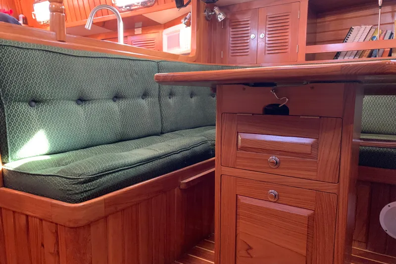 Elation Yacht Photos Pics Interior of 2004 Cabo Rico 42 Pilot yacht with green cushioned seating and wooden cabinetry.