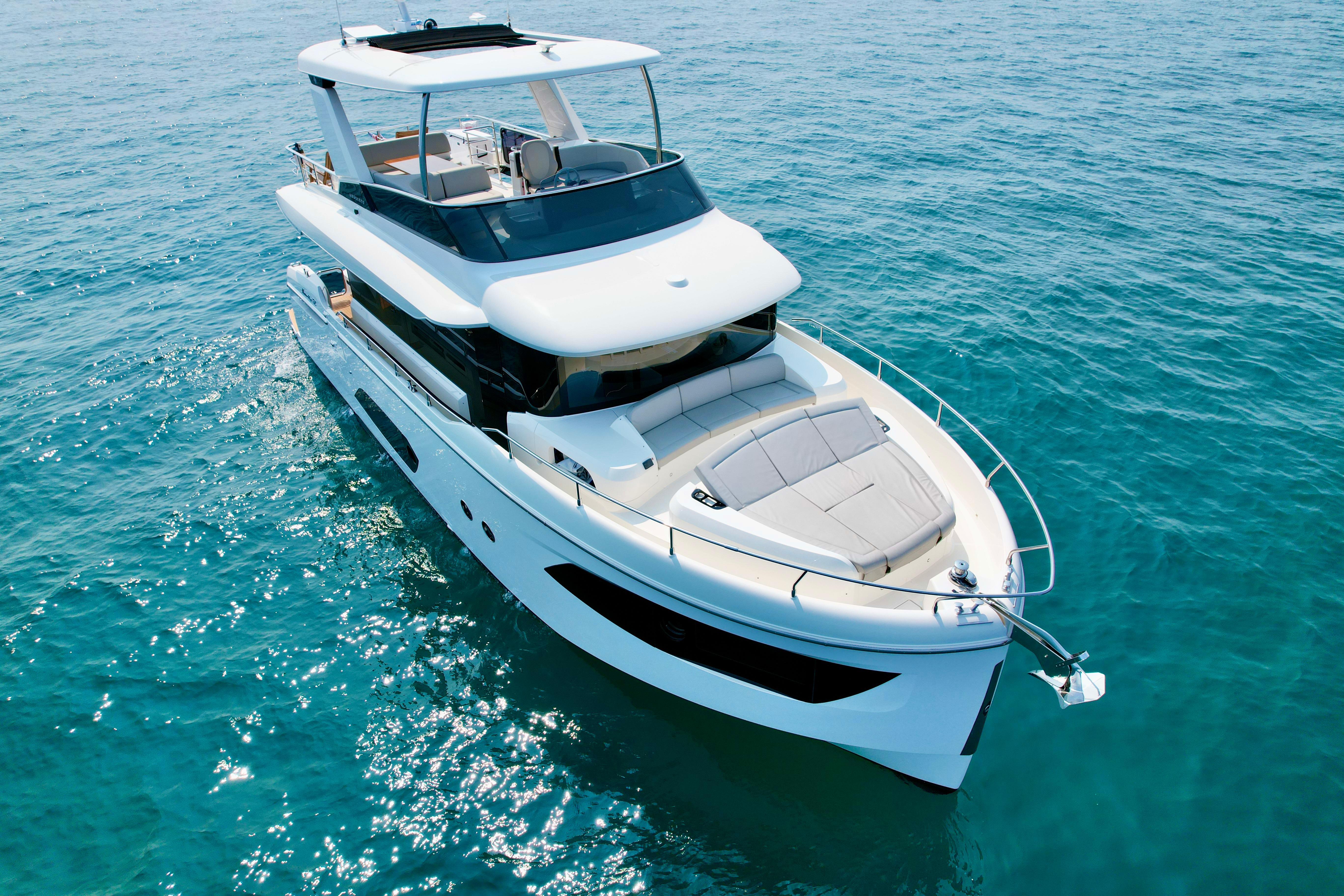 2023 Absolute 52 Navetta yacht cruising on clear blue water.