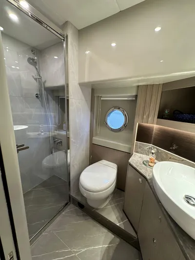 Just You Yacht Photos Pics Luxurious bathroom in 2023 Absolute 52 Navetta yacht with modern fixtures and porthole window.