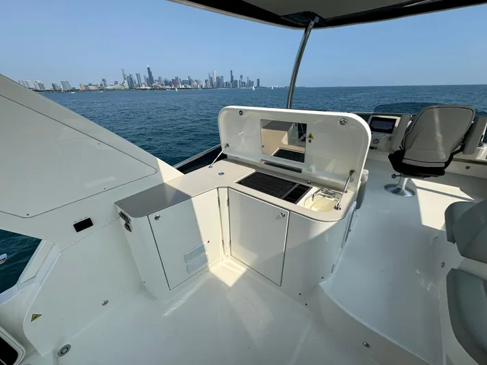 Just You Yacht Photos Pics Luxury yacht Absolute 52 Navetta 2023 with city skyline view, featuring outdoor kitchen.