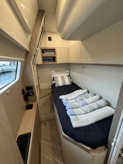Just You Yacht Photos Pics 2023 Absolute 52 Navetta cabin with single bed, window, and storage shelves.