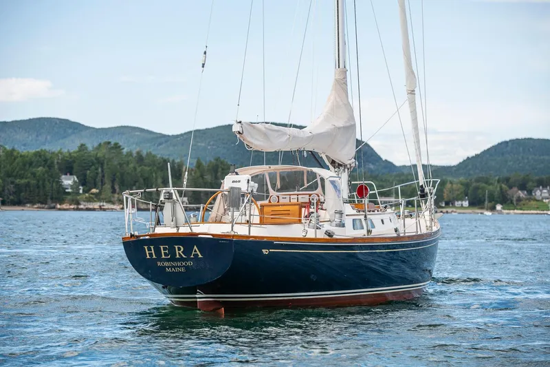Hera Yacht Photos Pics Hinckley Sou'wester 42 Sloop, 1994, sailing on a scenic lake with mountainous backdrop.