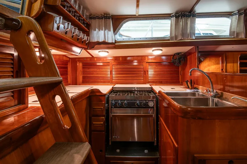 Hera Yacht Photos Pics Interior of 1994 Hinckley Sou'wester 42 Sloop, featuring wooden cabinetry and a compact kitchen area.