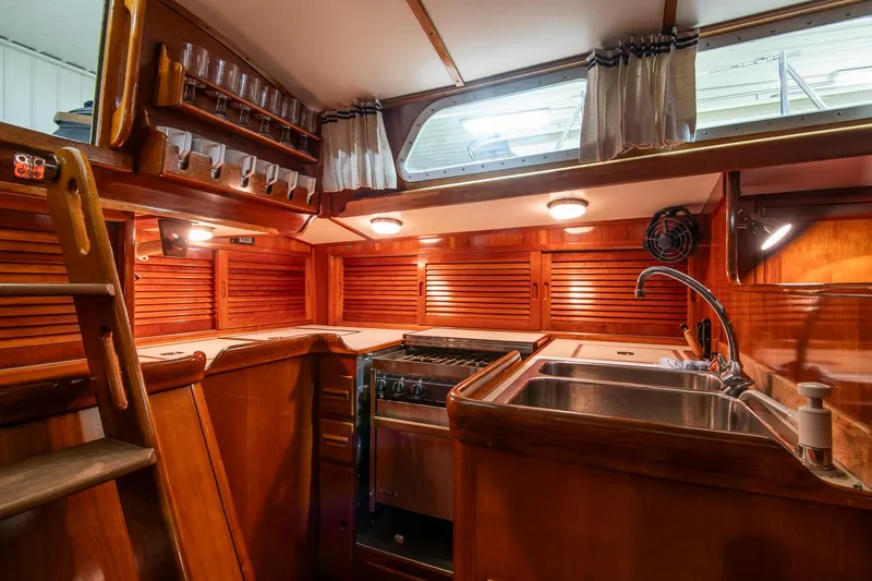 Hera Yacht Photos Pics 1994 Hinckley Sou'wester 42 Sloop interior kitchen with wood finish, sink, and stove.