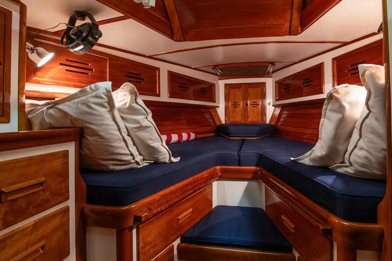 Hera Yacht Photos Pics Luxurious cabin interior of 1994 Hinckley Sou'wester 42 Sloop with wooden finish and blue cushions.