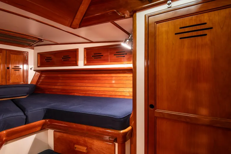Hera Yacht Photos Pics Interior of 1994 Hinckley Sou'wester 42 Sloop with wooden cabinetry and blue cushions.