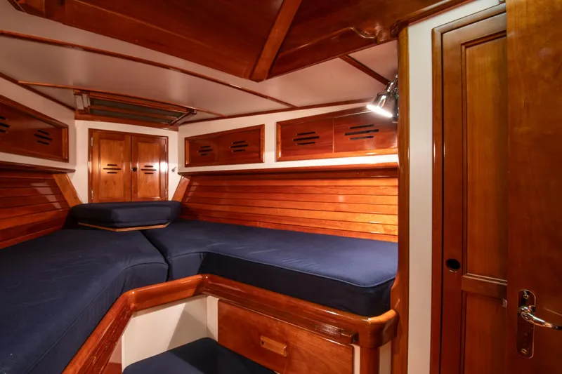 Hera Yacht Photos Pics Hinckley Sou'wester 42 Sloop 1994 interior cabin with wooden finish and blue cushions.