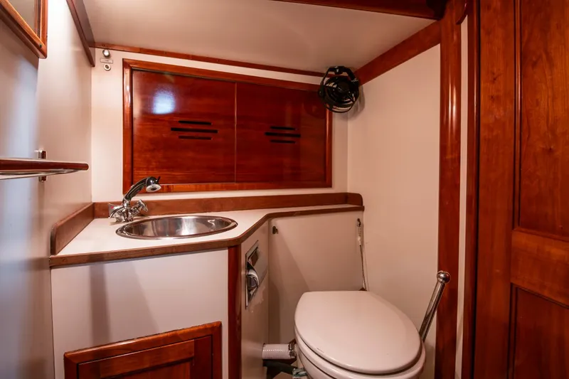 Hera Yacht Photos Pics Hinckley Sou'wester 42 Sloop 1994 bathroom with wooden cabinetry and stainless steel sink.