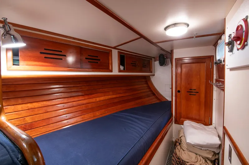 Hera Yacht Photos Pics Hinckley Sou'wester 42 Sloop 1994 cabin interior with wooden finish and blue bedding.