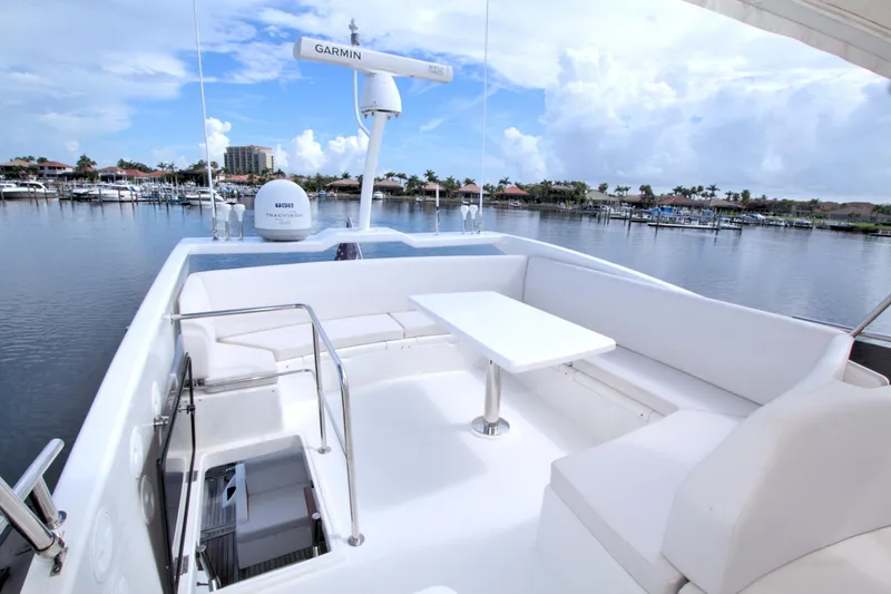 Wanderlust Yacht Photos Pics Luxurious 2015 Dyna 60 yacht deck with seating, table, and marina view.