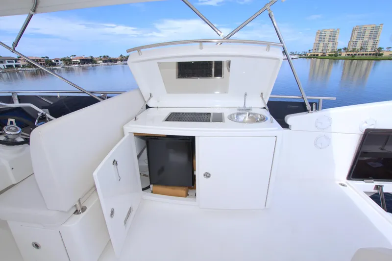 Wanderlust Yacht Photos Pics Outdoor kitchenette on a 2015 Dyna 60 yacht with sink and storage, overlooking waterfront.