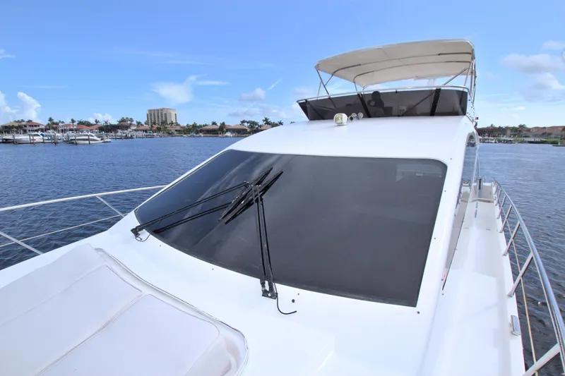 Wanderlust Yacht Photos Pics Luxury Dyna 60 yacht, 2015 model, cruising on a serene waterfront with clear blue skies.