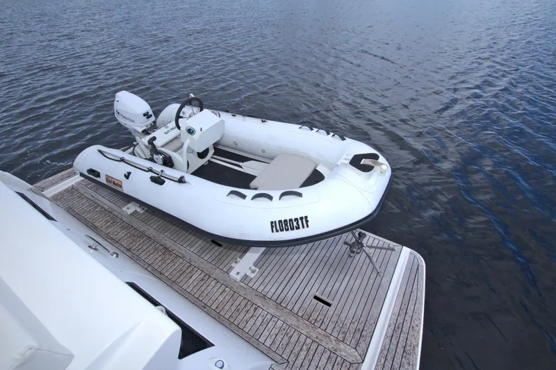Wanderlust Yacht Photos Pics Inflatable boat on wooden deck beside water, featuring a 2015 Dyna 60 model.