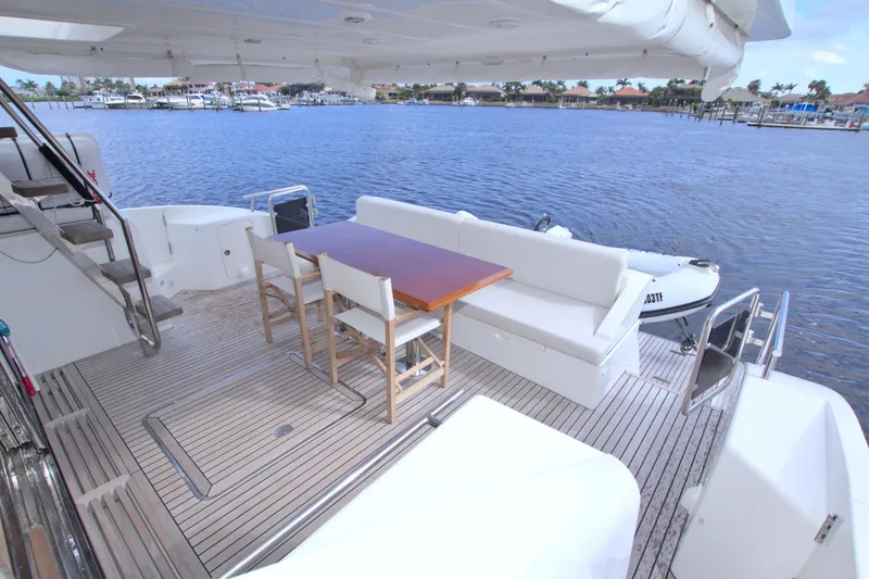 Wanderlust Yacht Photos Pics Luxurious 2015 Dyna 60 yacht deck with seating, table, and scenic waterfront view.