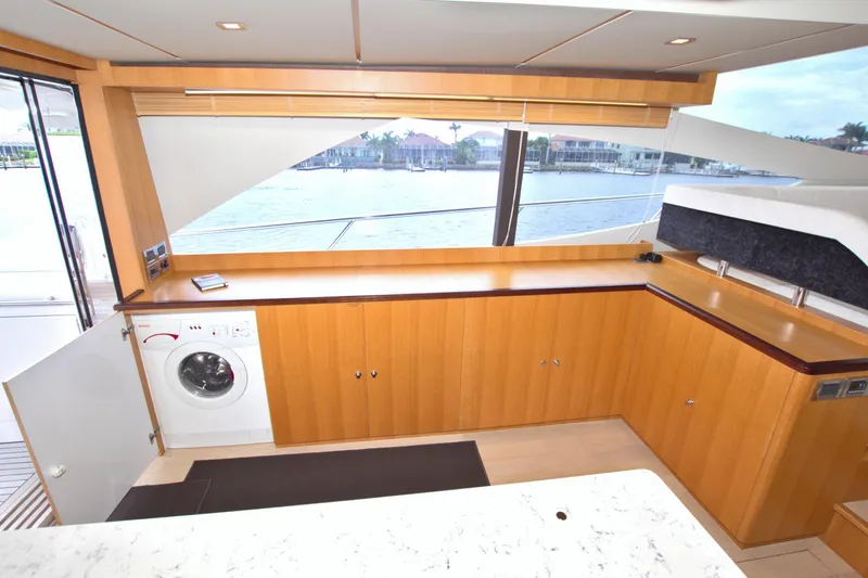 Wanderlust Yacht Photos Pics Luxurious interior of 2015 Dyna 60 yacht with wooden cabinetry and waterfront view.