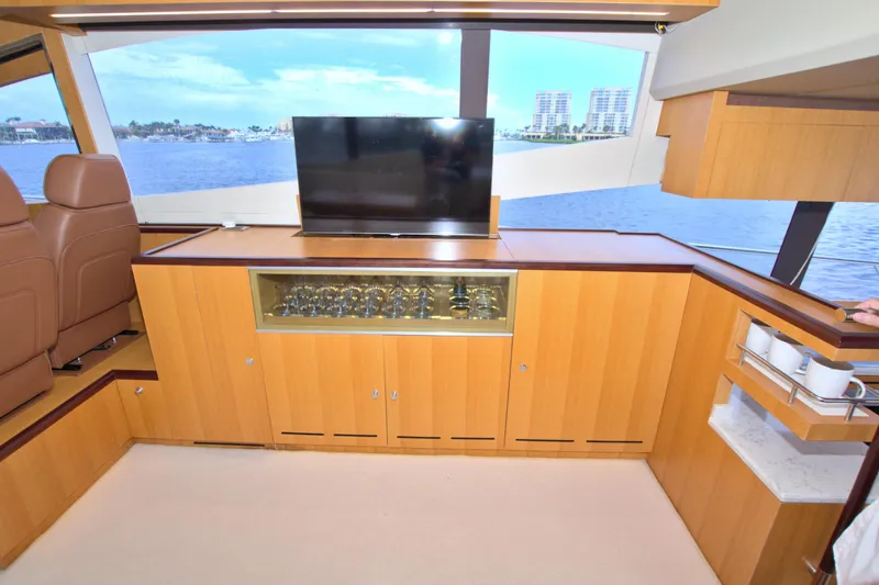 Wanderlust Yacht Photos Pics Luxurious interior of 2015 Dyna 60 yacht with TV, glass cabinet, and ocean view.