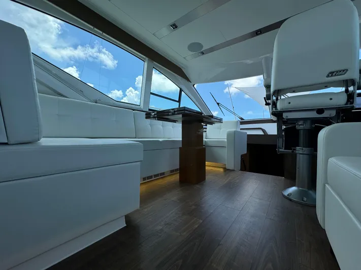 The 7 C's Yacht Photos Pics Luxurious interior of 2021 Cruisers Yachts 60 Cantius Flybridge with sleek seating and panoramic windows.