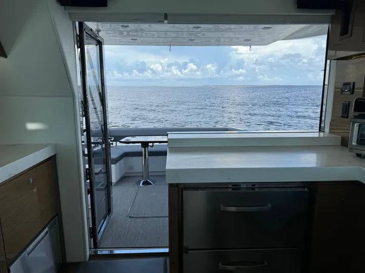 The 7 C's Yacht Photos Pics 2021 Cruisers Yachts 60 Cantius Flybridge interior with ocean view through open doors.