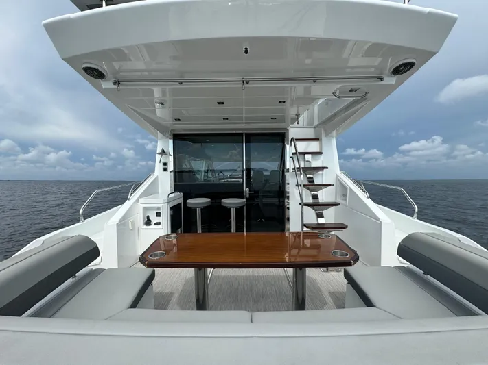 The 7 C's Yacht Photos Pics 2021 Cruisers Yachts 60 Cantius Flybridge, elegant deck with seating and ocean view.