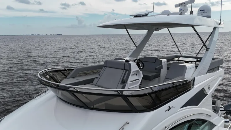 The 7 C's Yacht Photos Pics 2021 Cruisers Yachts 60 Cantius Flybridge on open water, showcasing sleek design and luxury features.
