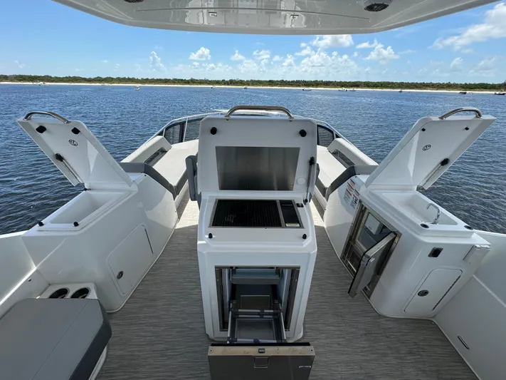 The 7 C's Yacht Photos Pics 2021 Cruisers Yachts 60 Cantius Flybridge deck with open storage and grill, overlooking water.