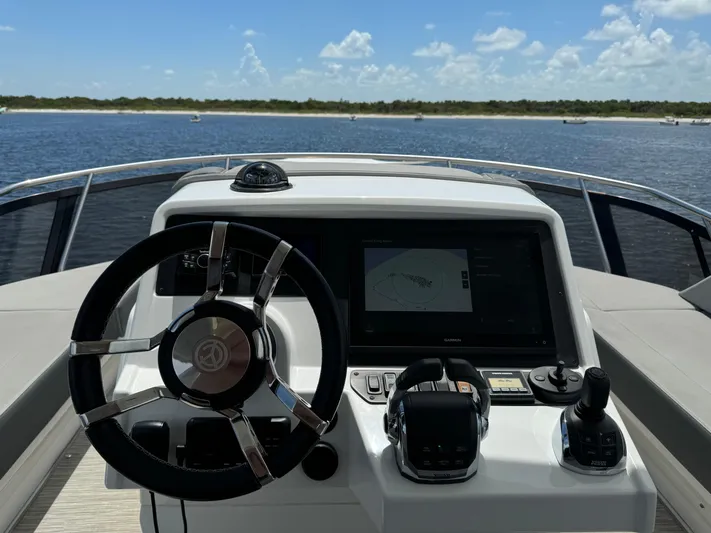 The 7 C's Yacht Photos Pics 2021 Cruisers Yachts 60 Cantius Flybridge helm with steering wheel and navigation display.