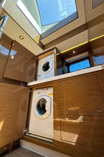 The 7 C's Yacht Photos Pics 2021 Cruisers Yachts 60 Cantius Flybridge laundry area with washer and dryer, skylight above.