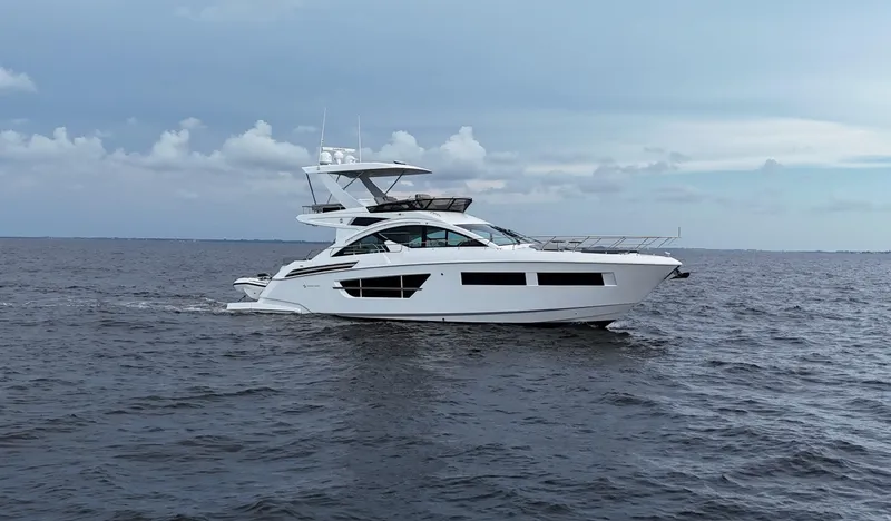The 7 C's Yacht Photos Pics 2021 Cruisers Yachts 60 Cantius Flybridge cruising on open water under cloudy skies.