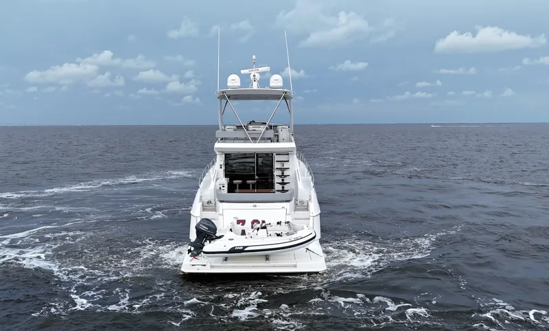 The 7 C's Yacht Photos Pics 2021 Cruisers Yachts 60 Cantius Flybridge on open sea, rear view.