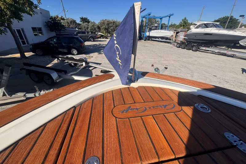  Yacht Photos Pics 2014 Chris-Craft Launch 28 boat with wooden deck and flag, parked near other boats.