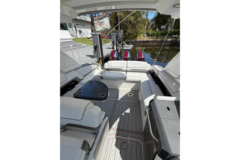  Yacht Photos Pics 2020 Formula 330 Crossover Bowrider OB interior with seating and table, docked by water.