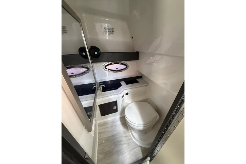  Yacht Photos Pics 2020 Formula 330 Crossover Bowrider OB bathroom interior with modern fixtures and porthole windows.