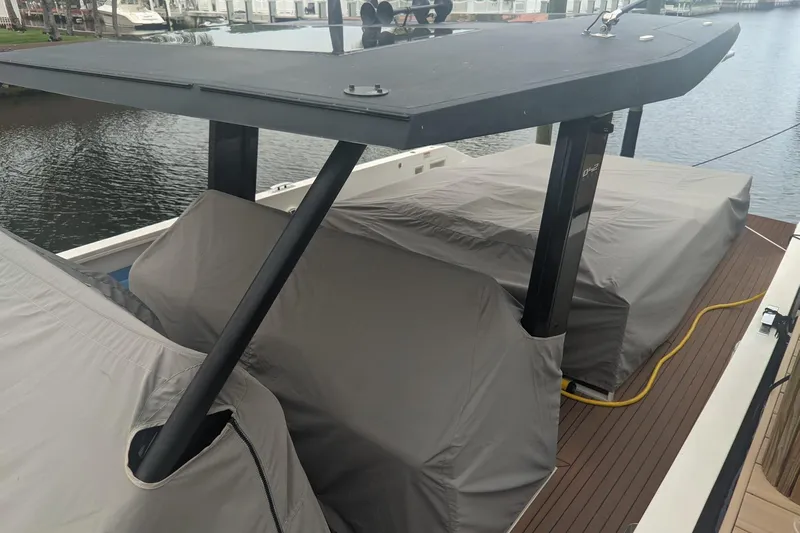  Yacht Photos Pics 2021 De Antonio Yachts Express with covered deck, docked by the water.