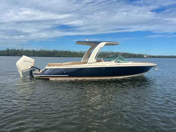  Yacht Photos Pics 2024 Chris-Craft Launch 25 GT boat on calm water under a partly cloudy sky.