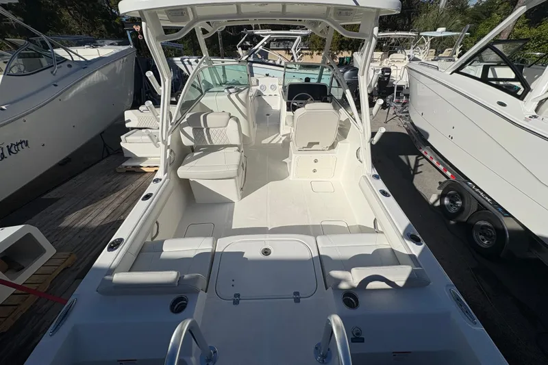  Yacht Photos Pics 2025 World Cat 230 DC boat interior with seating and helm, docked among other boats.